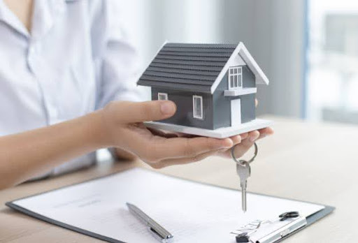 holding small house with key
