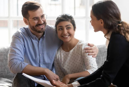 couple smiling with real estate agent
