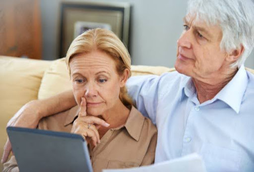 older couple thinking with laptop