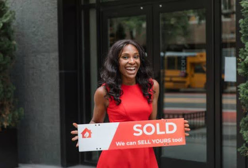 real estate agent holding sold sign
